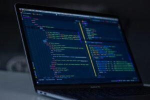 Laptop screen showing a code editor with a project file structure, representing the llms.txt technical implementation guide