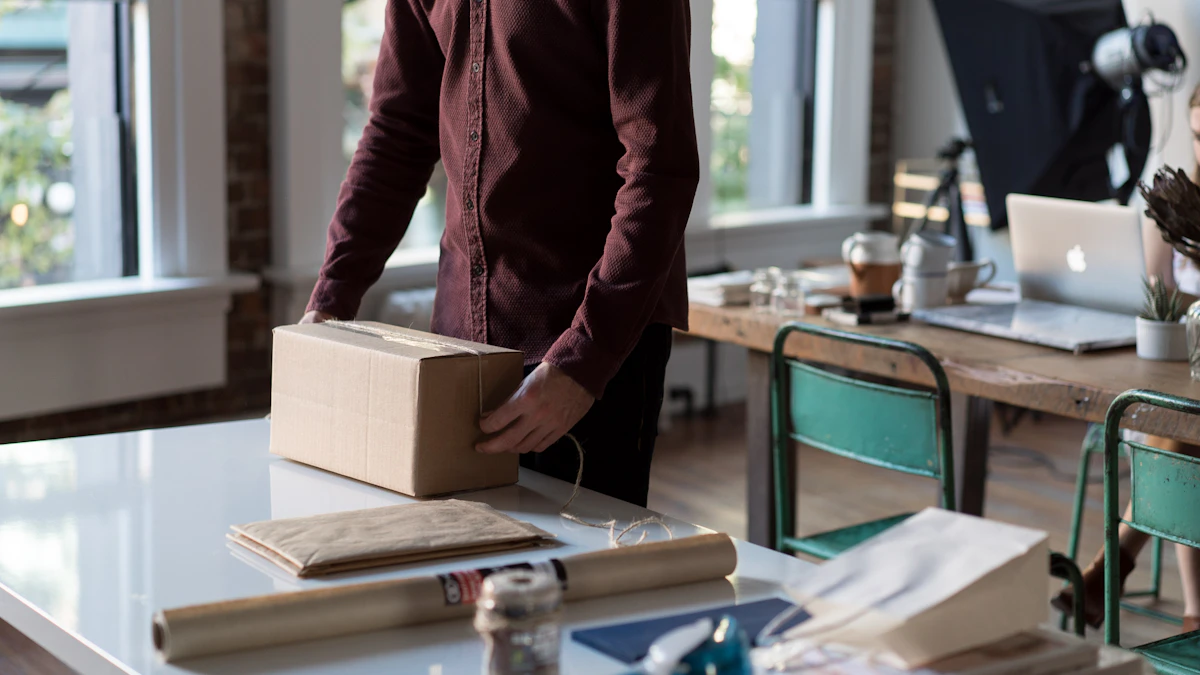 Running a Shopify Store's Day-to-Day Operations Small online store owner packing a cardboard shipping box on a table, with a laptop and product photography setup visible in the background